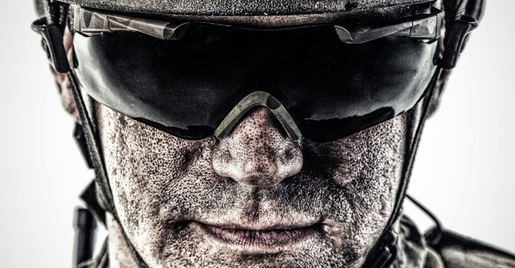 Man in helmet wearing dark tinted safety glasses